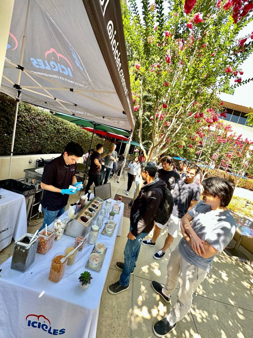 The branded Icicles canopy set up outdoors with guests lined up at a company event