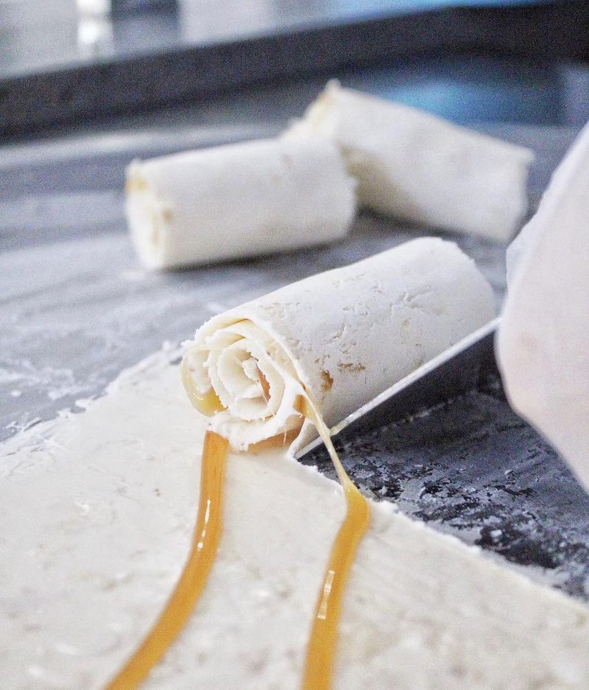 A roll being scraped off the frozen pan with caramel