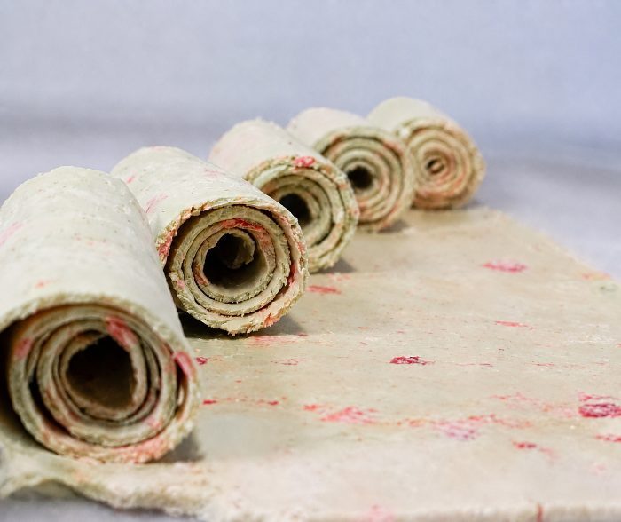 Fresh ice cream rolls lined up on the frozen pan